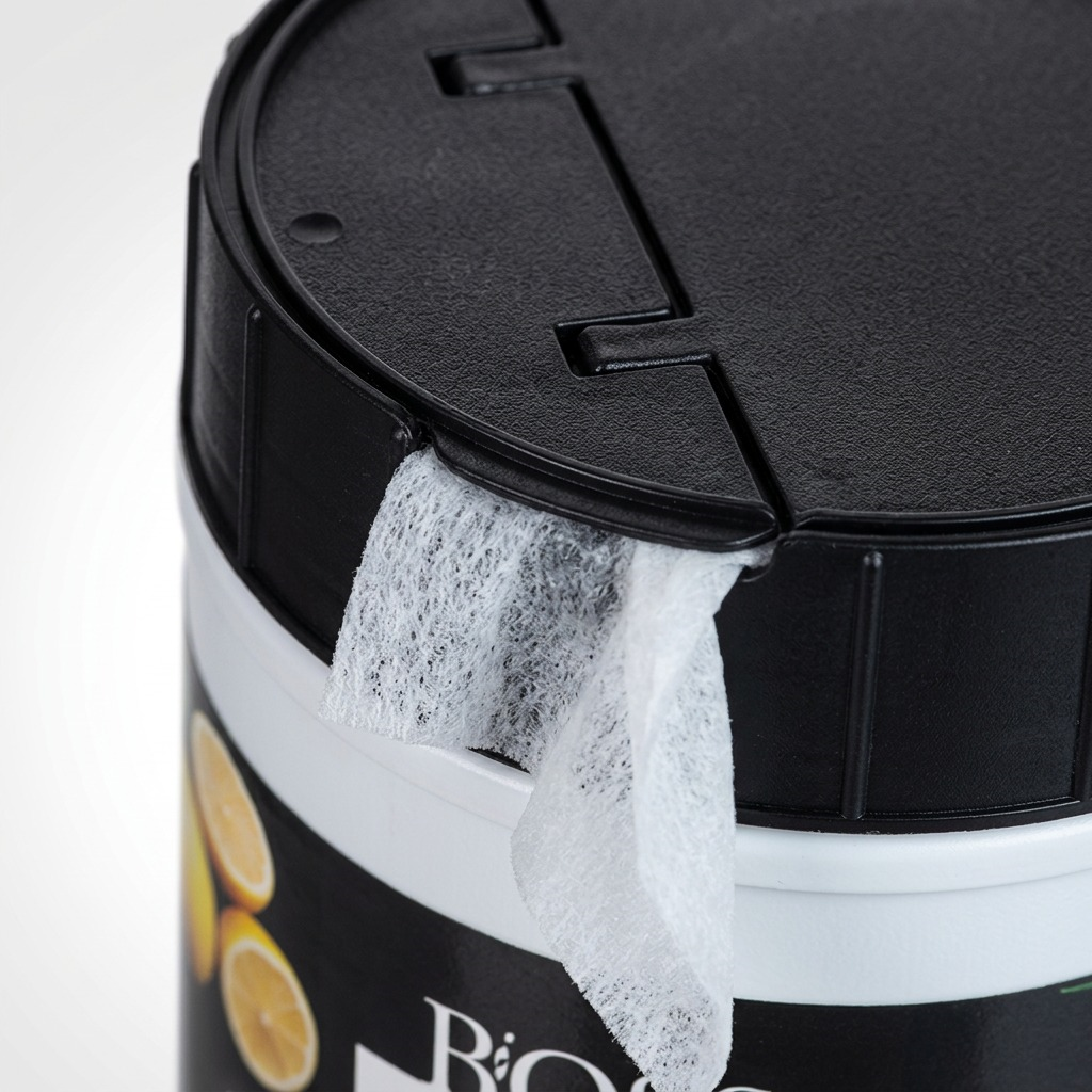 Macro view of a white BiOSS disinfecting wipe emerging from the black dispenser lid of a canister.