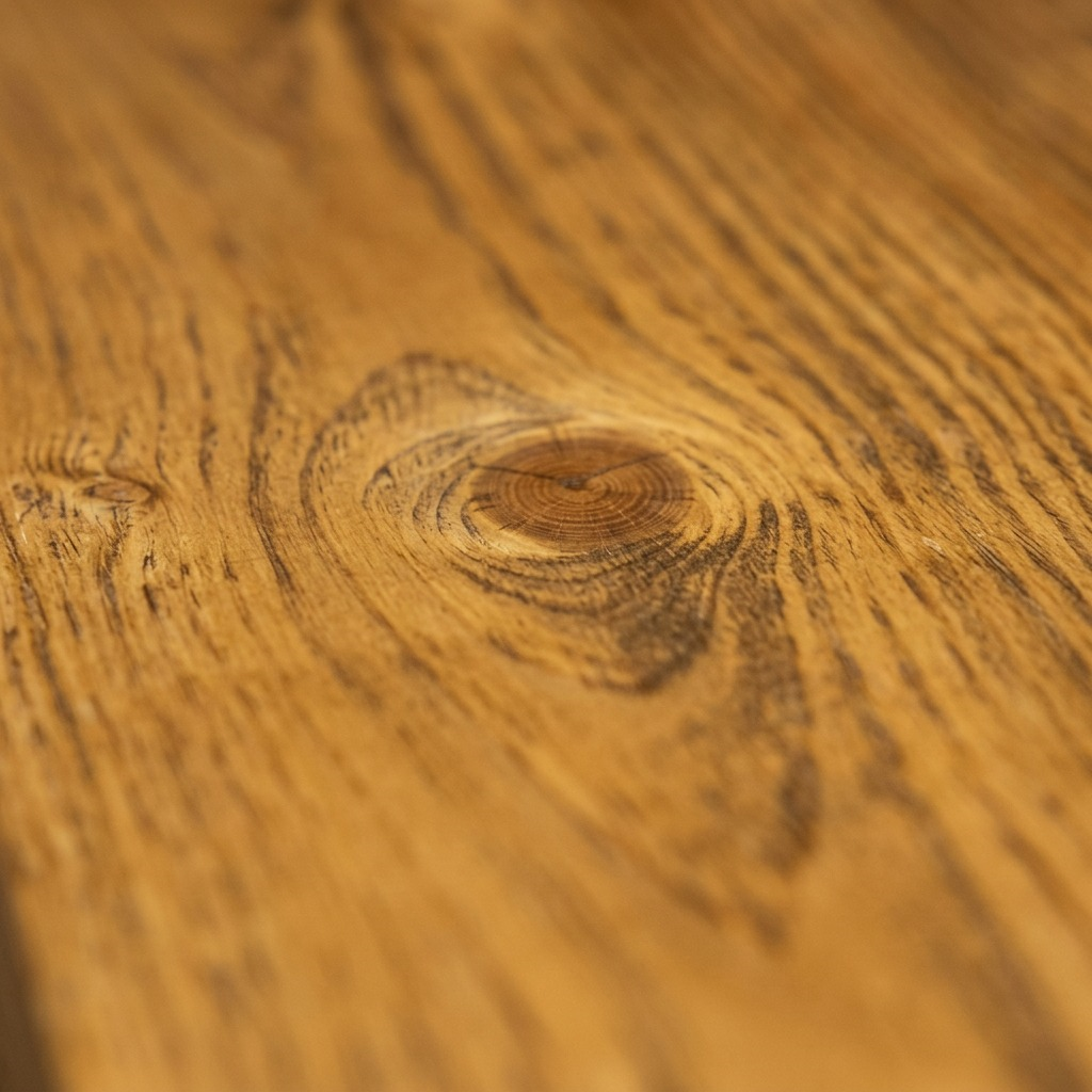 An extreme macro photograph capturing the rich honey-colored wood grain, knots, and smooth matte finish of the Entrepot La Grange inc shelf.